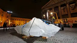 Petugas saat menurunkan balok es untuk diletakkan di Place du Pantheon Paris, Perancis, Kamis (3/12). Ini merupakan proyek pemerintah paris untuk membuat pertunjukan yang dinamakan Ice Watch Paris. (REUTERS/Benoit Tessier)