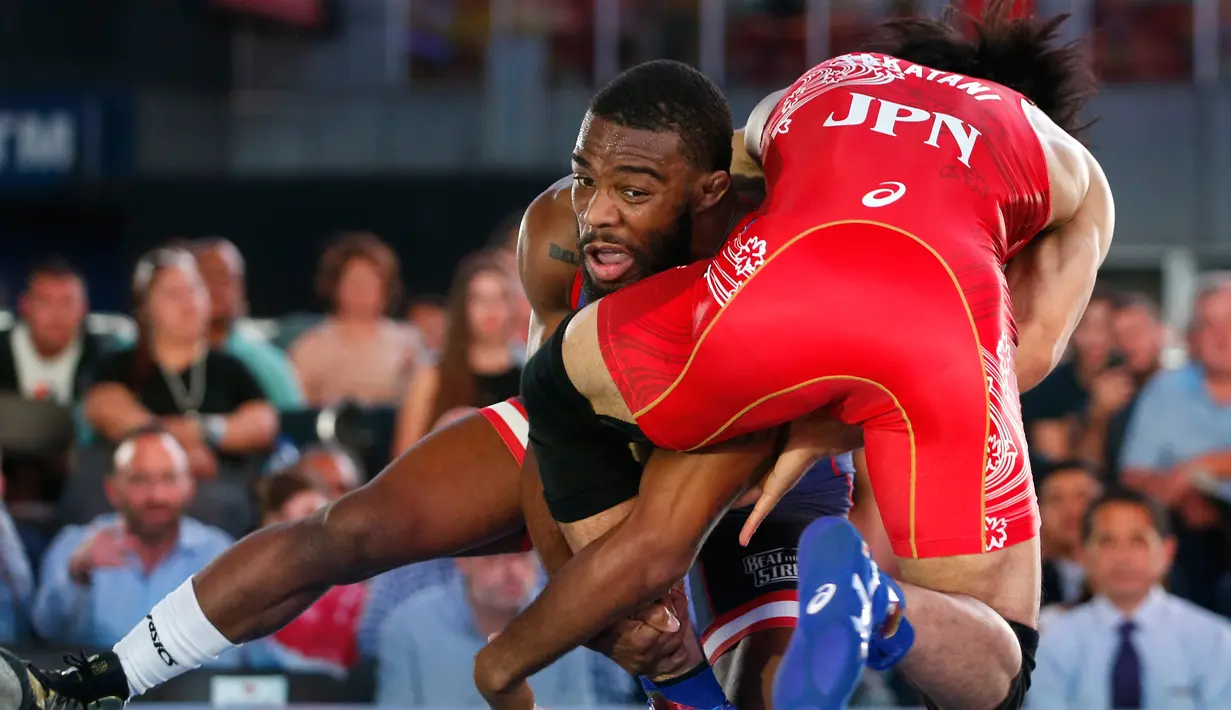 Jordan Burroughs dari Amerika Serikat berusaha membanting Sohsuke Takatani dari Jepang saat pertandingan gulat "Beat the Streets" di New York Times Square, (17/5). (AP Photo/Kathy Willens)