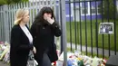 Dua orang guru tak kuasa menahan air matanya saat melintasi karangan bunga untuk Anne Maguire, Leeds, Inggris utara, Selasa (29/04/2014) (Reuters/Darren Staples).