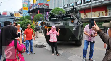 Seorang perempuan berselfie di depan panser Anoa milik TNI di LTC Glodok, Jakarta, Jumat (4/11). Anoa itu diparkir di depan LTC Glodok untuk mengantisipasi jika terjadi kerusuhan di pusat perbelanjaan tersebut. (Liputan6.com/Angga Yuniar)