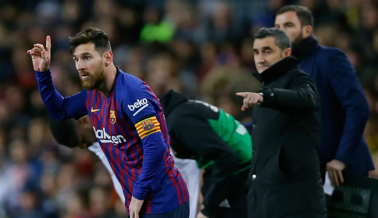 Pemain Barcelona, Lionel Messi (kiri) memasuki lapangan saat akan menghadapi Valencia dalam lanjutan Liga Spanyol di Camp Nou, Spanyol, Minggu (3/2). Dua gol Messi membuat pertandingan berakhir 2-2. (AP Photo/Manu Fernandez)