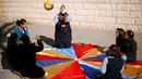 Hiba Al-Sharfa bermain bola bersama muridnya di sekolah Asosiasi Hak Hidup di Kota Gaza (21/12). Hiba Al-Sharfa telah membuktikan bahwa Down Syndrome tidaklah menjadi hambatan untuk meraih cita-citanya. (Reuters/Suhaib Salem)