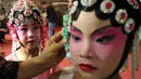 Anak-anak memakai riasan wajah sebelum menampilkan Opera Hahaqiang di Mumendian, Qingxian, Provinsi Hebei, China, 27 Agustus 2020. Opera Hahaqiang terdaftar sebagai warisan budaya tak benda nasional China pada 2006. (Xinhua/Mu Yu)