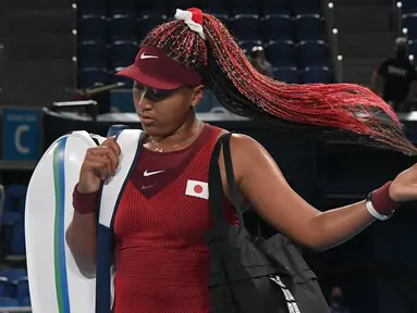 Petenis Jepang Naomi Osaka meninggalkan lapangan setelah dikalahkan Marketa Vondrousova dari Republik Ceko dalam pertandingan tenis putaran ketiga tunggal putri Olimpiade Tokyo 2020 di Ariake Tennis Park di Tokyo (27/7/2021). Naomi kalah dari Marketa Vondrousova 6-1, 6-4. (AFP/Tiziana Fabi)