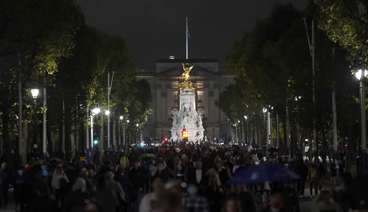 Orang-orang berjalan menyusuri The Mall yang mengarah ke Istana Buckingham menyusul pengumuman meninggalnya Ratu Elizabeth II, di London, Kamis, 8 September 2022. (James Manning/PA via AP)