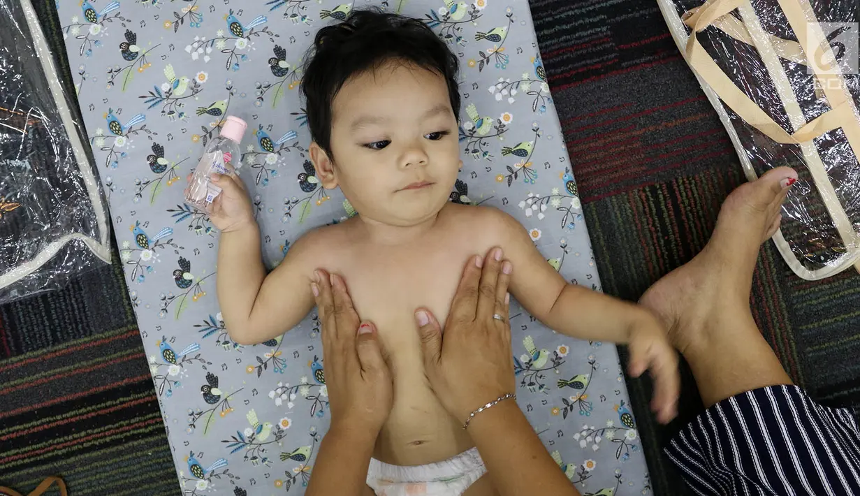 Seorang bayi mengikuti acara pijat massal bayi di Gedung Kementerian Kesehatan, Jakarta, Selasa (7/11). Acara tersebut digelar dalam rangka menyambut peringatan Hari Kesehatan Nasional ke-53. (Liputan6.com/Immanuel Antonius)