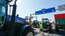 Seorang warga berjalan di tengah traktor  di jalan raya A6 di Limonest, dekat Lyon, Prancis (23/7/2015). Petani Perancis memprotes kembali ketidak seimbangan keuntungan yang diperoleh antara petani dan pengecer. (REUTERS/Robert Pratta)