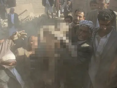 Warga saat berhasil mengevakuasi jasad bocah yang tertimbun reruntuhan bangunan setelah serangan udara Arab Saudi menghantam Saada, Yaman, Selasa (31/8). Serangan tersebut menewaskan setidaknya 16 orang, termasuk bocah malang itu. (REUTERS/Naif Rahma)