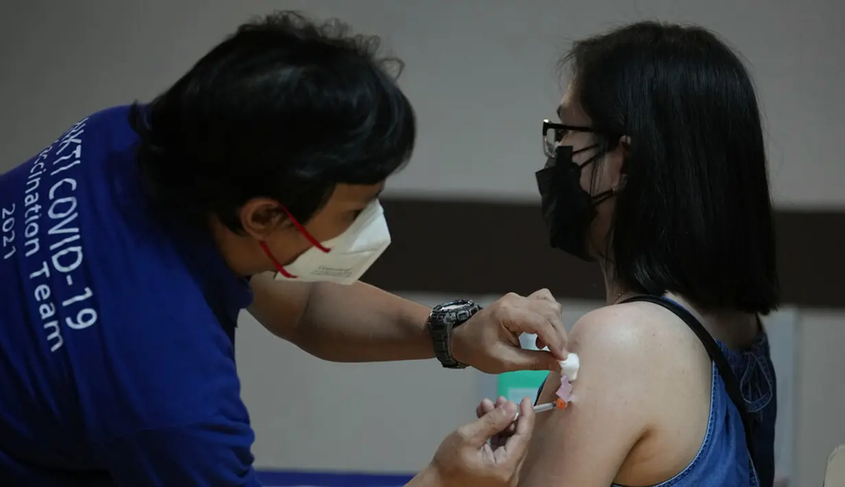 Seorang petugas kesehatan disuntik dengan vaksin COVID-19 Pfizer di National Kidney and Transplant Institute, Quezon City, Filipina, 17 November 2021. Pemerintah Filipina mulai menyuntikkan booster vaksin COVID-19 kepada pekerja garis depan. (AP Photo/Aaron Favila)