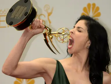 Setelah dinobatkan menjadi Penulis Cerita Terbaik dalam Emmy Awards ke-66, Sarah Silverman berpose menggigit piala untuk mengekspresikan kebahagiaannya (AFP PHOTO/ Mark Ralston)