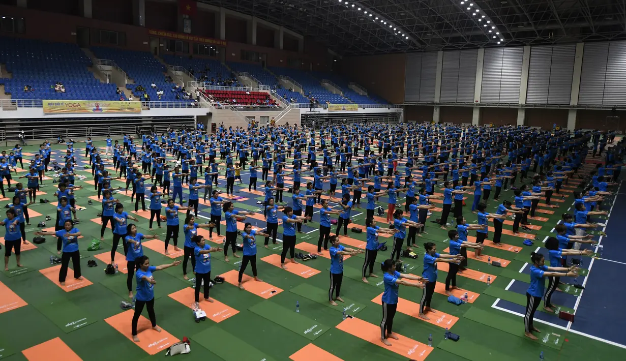 Para peserta menghadiri sesi yoga massal untuk memperingati Hari Yoga Internasional yang jatuh pada 21 Juni di Hanoi, Vietnam, Sabtu (16/6). (AFP PHOTO/Nhac NGUYEN)