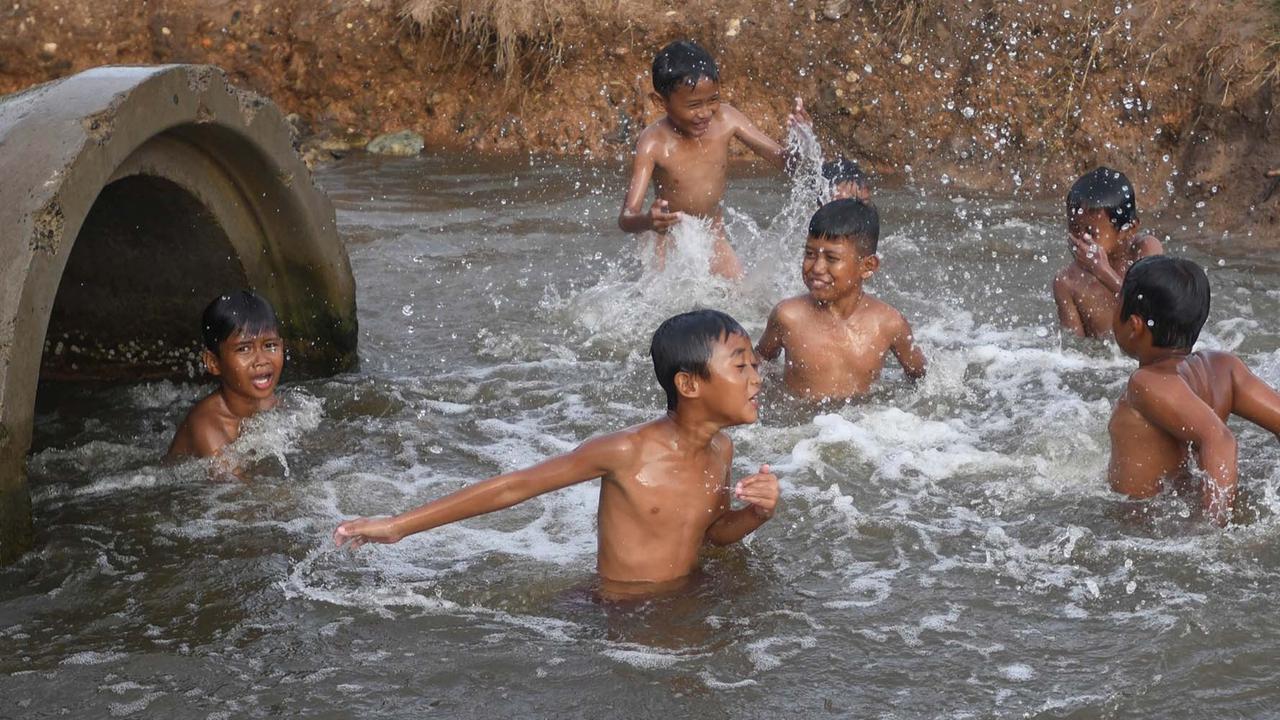 FOTO: Keceriaan Anak-Anak Bermain Pada Saluran Air di Tanjung Pasir