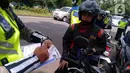 Polisi menilang pengendara sepeda motor saat razia di kawasan BSD, Tangerang Selatan, Banten, Kamis (23/1/2020). Polres Tangerang Selatan menggelar razia untuk meningkatkan tertib berlalu lintas, disiplin kendaraan, dan mempersempit gerak pelaku kejahatan jalanan. (merdeka.com/Arie Basuki)