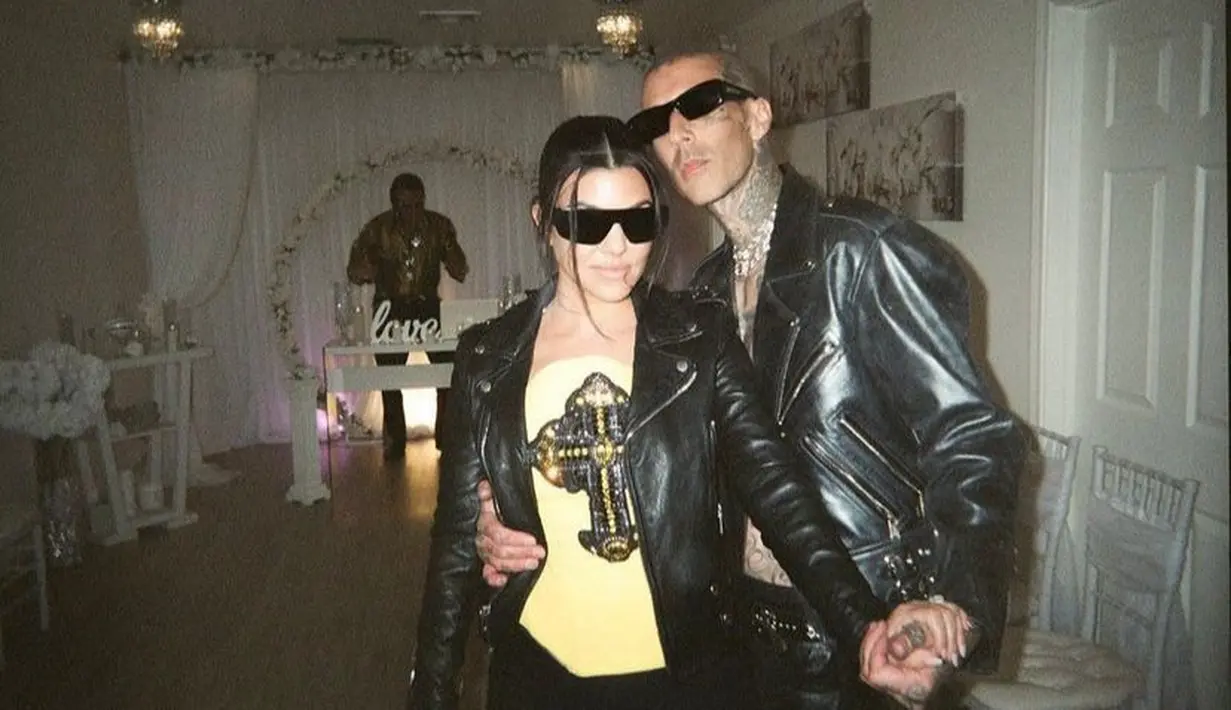 Tanpa gaun putih atau veil menyapu lantai, Kourtney tampil nyentrik dengan jaket kulit. Penampilan perempuan 42 tahun ini semakin sempurna dengan bandeau top warna kuning. (Instagram/kourtneykardash).