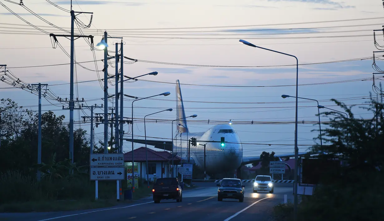 Sebuah pesawat Boeing 747 terlihat di persimpangan jalan raya Nakhon Pathom, Bangkok, Thailand (19/1). Pesawat penumpang ini tidak kembali aktif dan sengaja diletakkan dipersimpangan jalan. (AFP PHOTO / Christophe Archambault)