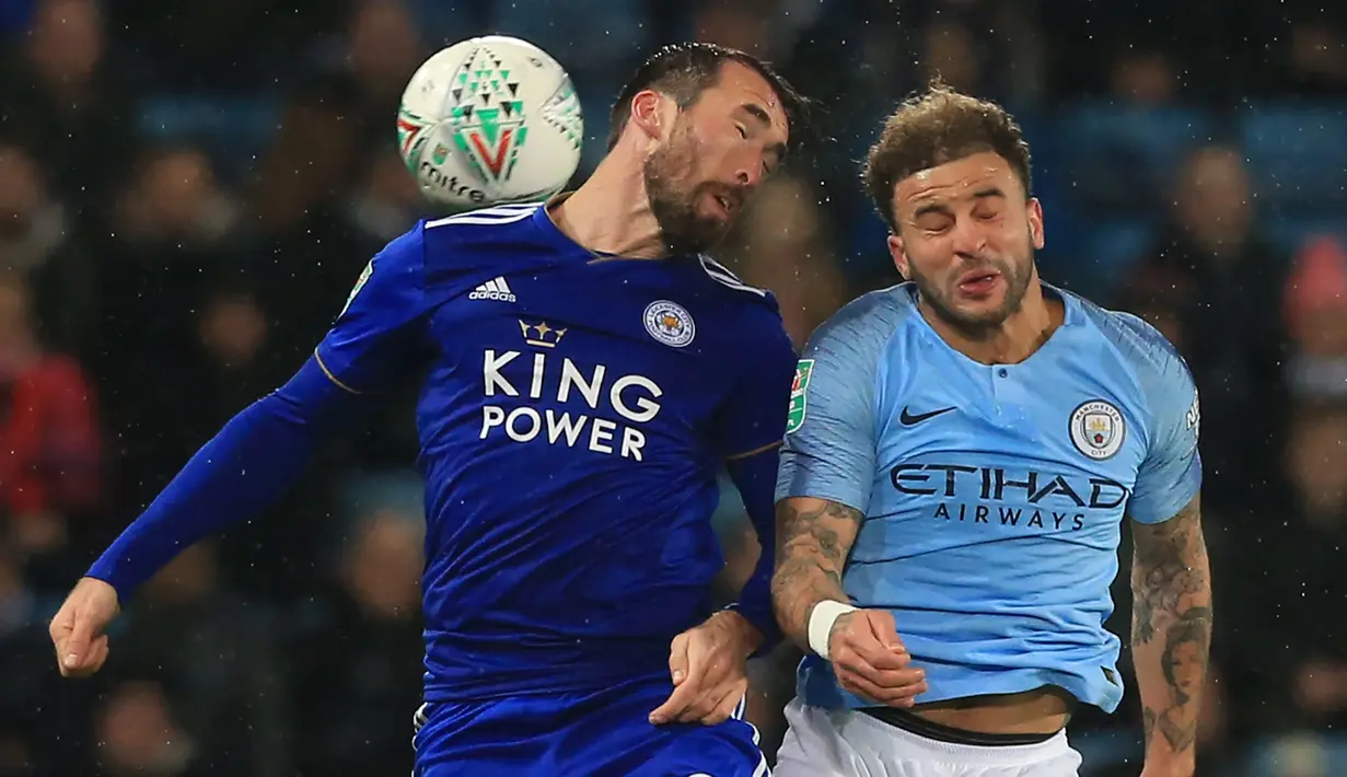 Bek Leicester, Christian Fuchs, duel udara dengan bek Manchester City, Kyle Walker, pada laga Piala Liga di Stadion King Power, Leicester, Selasa (18/12). Leicester kalah adu penalti dari City. (AFP/Lindsey Parnaby)