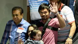Manny Pacquiao dan istrinya ,Jinkee, saat tiba di Bandar Udara Internasional Manila, Filipina setelah pertarungannya melawan Floyd Mayweather. (AFP PHOTO/TED ALJIBE)