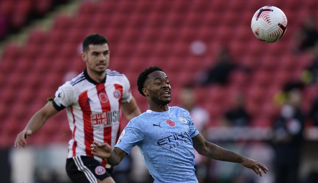 Penyerang Manchester City, Raheem Sterling, berebut bola dengan bek Sheffield United, John Egan, pada laga lanjutan Liga Inggris di Stadion Bramall Lane, Sabtu (31/10/2020) malam WIB. Manchester City menang 1-0 atas Sheffield. (Tim Keeton/Pool via AP)
