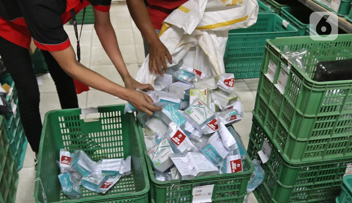 Pekerja menata paket obat COVID-19 di salah satu gerai ekspedisi SiCepat di Jalan K.S Tubun, Petamburan, Jakarta, Sabtu (17/7/2021). Pemerintah resmi membagikan 300 ribu paket obat gratis untuk pasien COVID-19 yang menjalani isolasi mandiri di Pulau Jawa dan Bali. (Liputan6.com/Herman Zakharia)