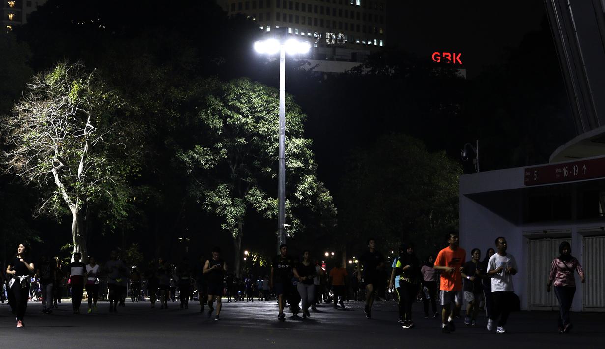 Sejumlah warga berlari di kawasan Stadion Utama Gelora Bung Karno, Senayan, Jakarta, Rabu (9/10). Olahraga lari pada malam hari di GBK menjadi pilihan pekerja ibu kota. (Bola.com/Yoppy Renato)
