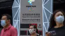 Seorang pria yang memakai masker untuk melindungi diri dari COVID-19 berjalan melewati layar yang menunjukkan jam hitung mundur ke Olimpiade Musim Dingin 2022 di Beijing (18/8/2021).  Pejabat tinggi Beijing menegaskan kembali perlunya anti-pencegahan yang ketat. (AP Photo/Mark Schiefelbein)