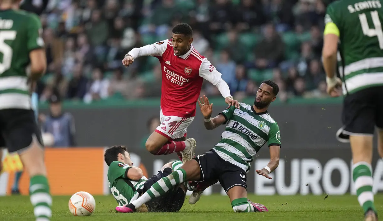 Pemain Arsenal, Reiss Nelson (tengah) berusaha melewati pemain Sporting CP pada laga leg pertama Liga Europa 2022/2023 di Jose Alvalade Stadium, Lisbon, Jumat (10/03/2023) dini hari WIB. Laga berakhir dengan skor imbang 2-2. (AP Photo/Armando Franca)