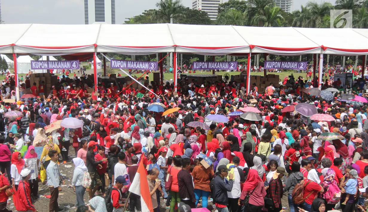 Warga antre untuk mendapatkan sembako gratis dalam acara "Untukmu Indonesia" di lapangan Monas, Jakarta, Sabtu (28/4). (Liputan6.com/Arya Manggala)
