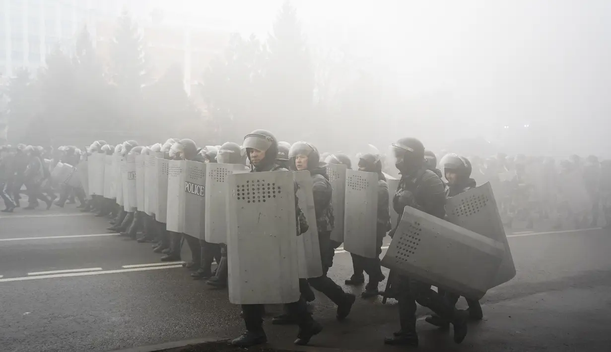 Polisi anti huru hara berjalan untuk menghadang demonstran selama protes di Almaty, Kazakhstan, Rabu (5/2/2022). Demonstran yang mencela kenaikan harga gas cair bentrok dengan polisi di kota terbesar Kazakhstan dan mengadakan protes di sekitar selusin kota lain di negara.(AP Photo/Vladimir Tretyakov