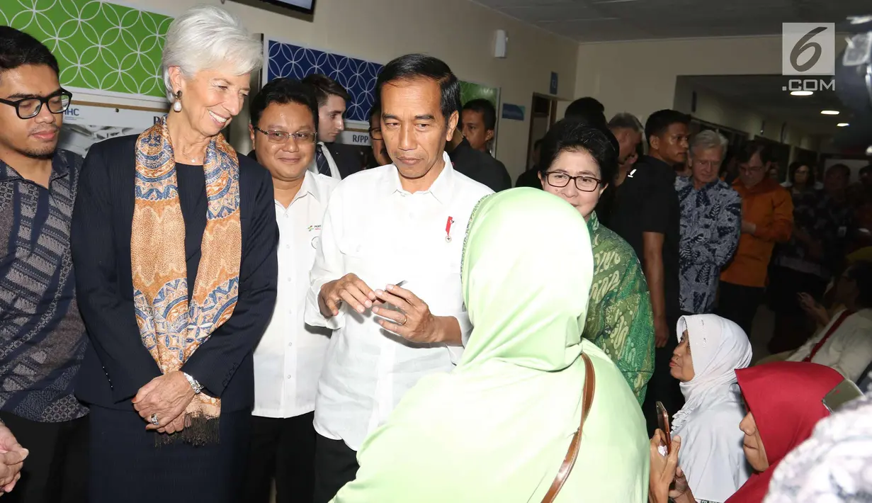 Presiden Joko Widodo dan Managing Director IMF Christine Lagarde berbincang dengan seorang pasien saat melihat fasilitas pelayanan Kartu Indonesia Sehat (KIS) di RSPP Jakarta, Senin (26/2). (Liputan6.com/Angga Yuniar)