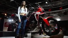 Model berpose di samping motor Honda Africa Win saat Indian Auto Expo 2018 di Greater Noida, New Delhi, India, (7/2). (AFP Photo/Sajjad Hussain)