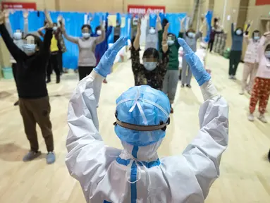 Petugas medis Yi Qin menjadi instruktur kebugaran fisik tradisional China untuk pasien COVID-19 di rumah sakit sementara di Distrik Jiangxia, Wuhan, Hubei, China (25/2/2020). Gelombang pertama sebanyak 23 pasien diizinkan pulang setelah menggunakan pengobatan tradisional China. (Xinhua/Shen Bohan)