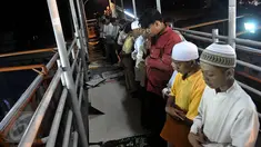 Puluhan warga melaksanakan ibadah Salat Tarawih pertama di kawasan Pasar Gembrong, Jakarta, Rabu (17/6/2015). Terbatasnya jumlah daya tampung musholla membuat warga terpaksa salat di jembatan. (Liputan6.com/Johan Tallo)