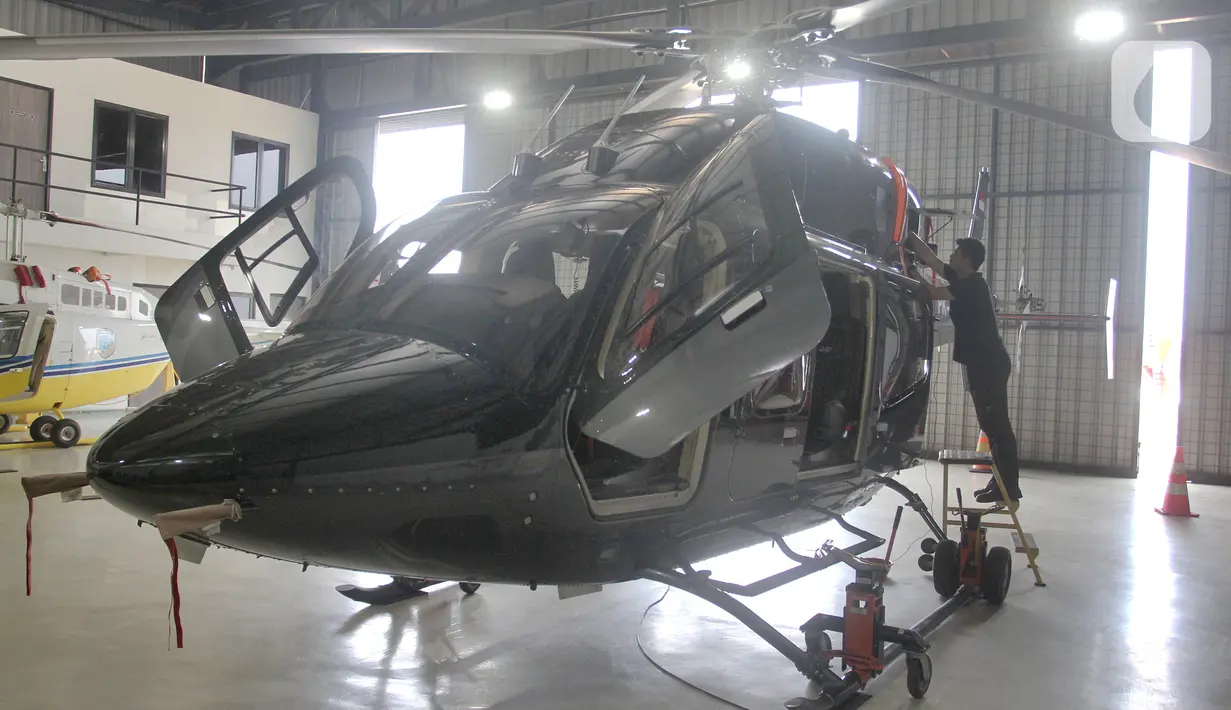 Pekerja mempersiapkan helikopter yang akan dipajang pada pameran helikopter "Heli Expo Asia 2023" di Cengkareng Heliport Bandara Soekarno Hatta, Tangerang, Banten,Rabu(14/6/2023). (merdeka.com/Arie Basuki)