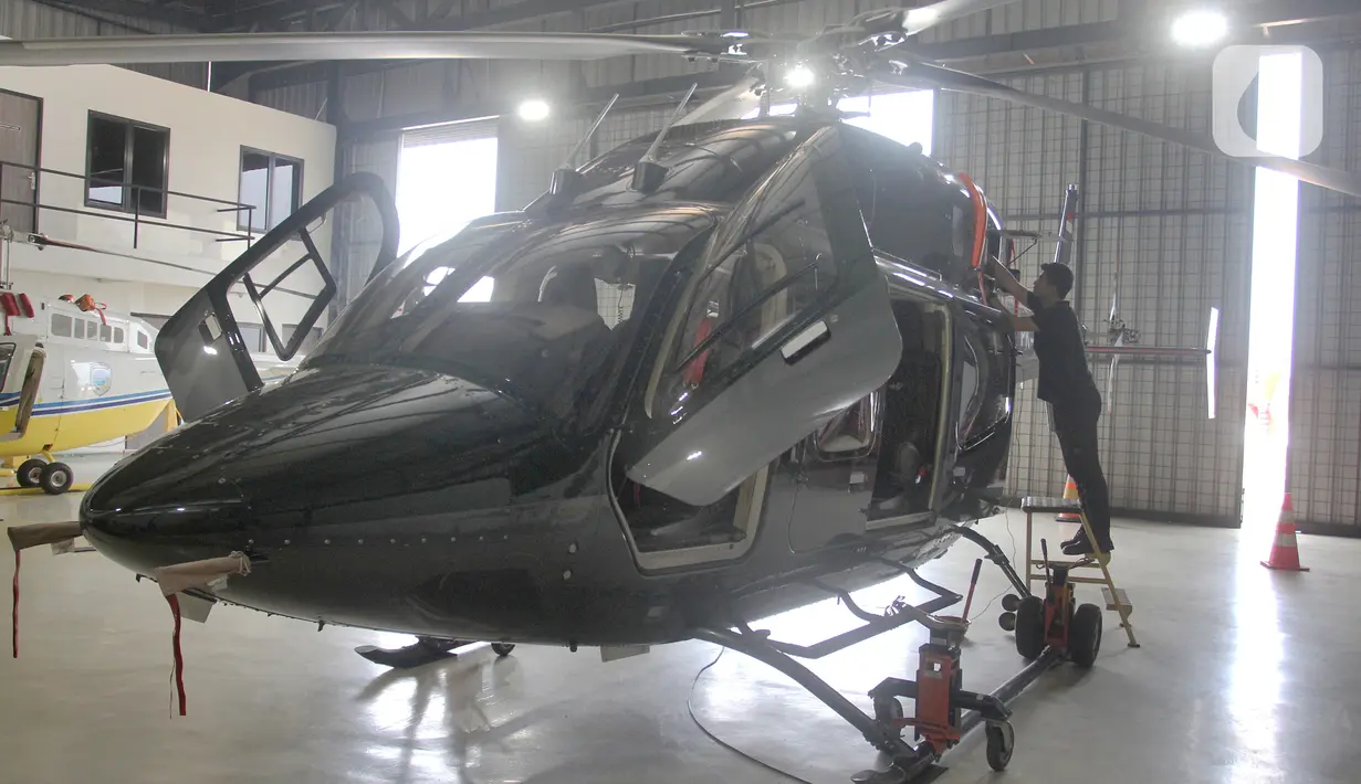 Pekerja mempersiapkan helikopter yang akan dipajang pada pameran helikopter "Heli Expo Asia 2023" di Cengkareng Heliport Bandara Soekarno Hatta, Tangerang, Banten,Rabu(14/6/2023). (merdeka.com/Arie Basuki)