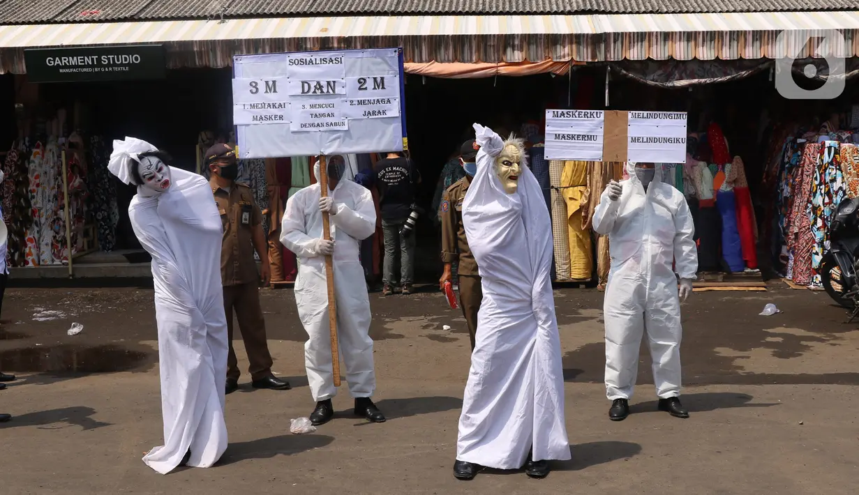 Petugas Kecamatan Larangan berkeliling mengenakan pakaian pocong saat melakukan sosialisasi di Pasar Cipadu, Kota Tangerang, Rabu (16/9/2020). Pocong ini bentuk sosialiasi agar warga memperhatikan perilaku 3M COVID, yaitu memakai masker, menjaga jarak dan mencuci tangan. (Liputan6.com/Angga Yuniar)