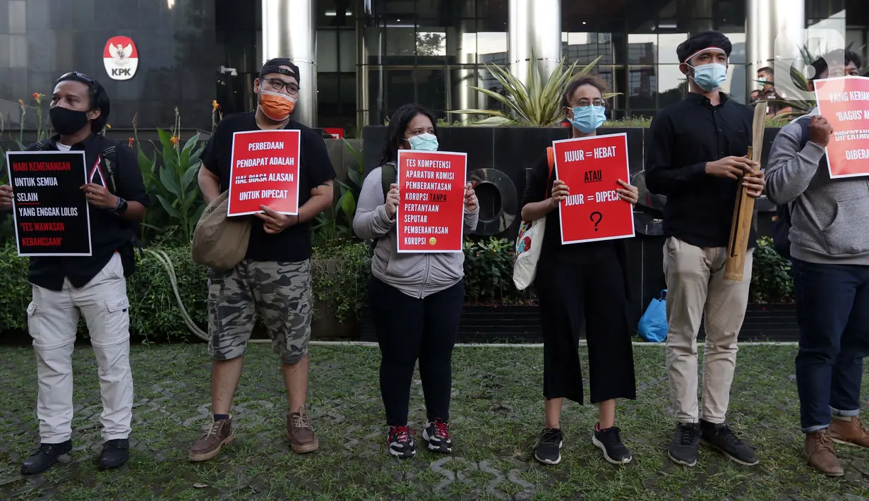 Peserta aksi dari Koalisi Masyarakat Sipil AntiKorupsi membawa poster saat berunjukrasa di depan Gedung KPK Jakarta, Selasa (18/5/2021). Dalam aksinya, sambil membunyikan kentongan mereka memberi dukungan kepada 75 pegawai KPK yang dinyatakan tidak lulus TWK. (Liputan6.com/Helmi Fithriansyah)