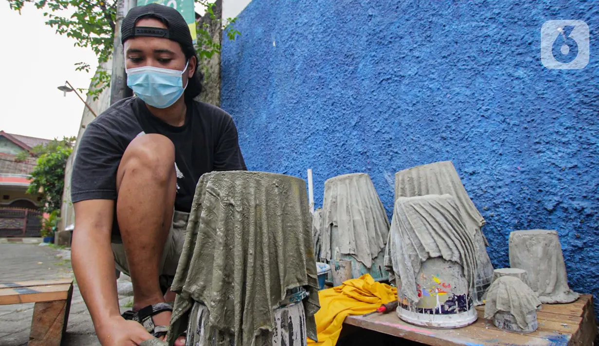 Seorang anak muda menyelesaikan pembuatan pot tanaman berbahan dasar kain bekas di  Cibodas, Kota Tangerang, Minggu (3/10/2021). Para pemuda ini memanfaatkan PPKM untuk membuat Pot tanaman daur ulang yang dipasarkan mulai harga Rp. 30 ribu hingga Rp. 80 ribu. (Liputan6.com/Angga Yuniar)