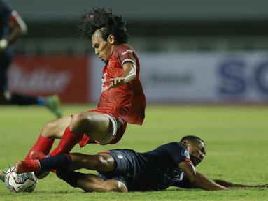 Pemain Arema FC, Dendi Santoso, berebut bola dengan pemain PSM Makassar, Rasyid Bakri, pada laga BRI Liga 1 di Stadion Pakansari, Bogor, Minggu (5/9/2021). Kedua tim bermain imbang 1-1. (Foto: Bola.com/M Iqbal Ichsan)