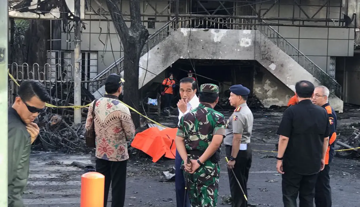Presiden Joko Widodo (Jokowi) berbincang dengan Panglima TNI Mareskal Hadi Tjahjanto saat meninjau Gereja Kristen Indonesia yang menjadi lokasi ledakan bom di Jalan Arjuna, Surabaya, Minggu (13/5). (Liputan6.com/Istimewa)