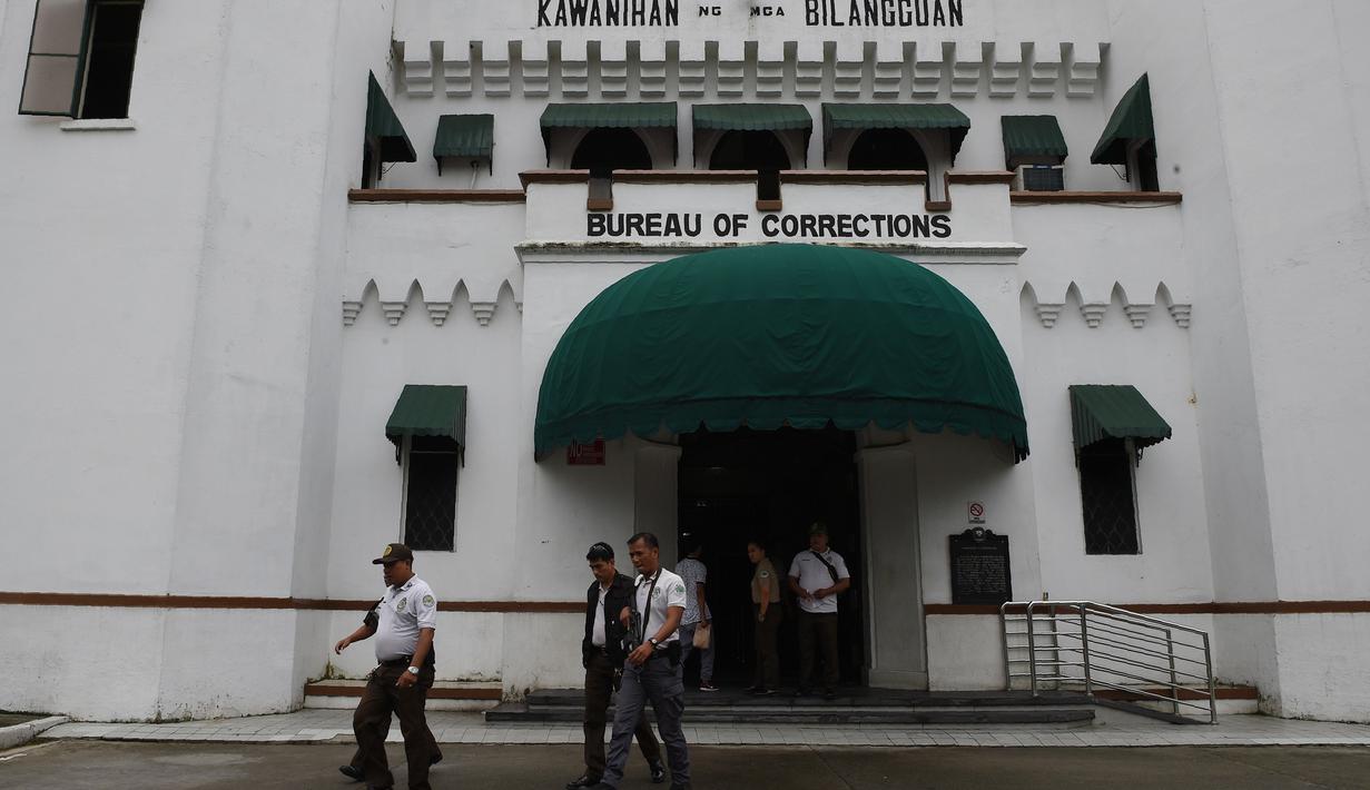 Penyidik berjalan melewati bangunan utama sebuah penjara di Filipina usai insiden kerusuhan, Rabu (28/9). Satu anggota geng narkoba tewas dan tiga napi terluka dalam kerusuhan di penjara yang terkenal dengan kekerasan dan kekejamannya. (TED Aljibe/AFP)