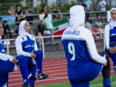 Pesepakbola wanita Iran melakukan pemanasan sebelum pertandingan melawan Jerman di Discover Football tournament di Berlin, Jerman (31/8). Tampil mengunakan hijab pesepakbola wanita Iran jadi pusat perhatian penonton.(REUTERS/Stefanie Loos)