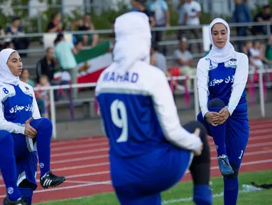 Pesepakbola wanita Iran melakukan pemanasan sebelum pertandingan melawan Jerman di Discover Football tournament di Berlin, Jerman (31/8). Tampil mengunakan hijab pesepakbola wanita Iran jadi pusat perhatian penonton.(REUTERS/Stefanie Loos)