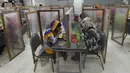 Para buruh makan di kantin pabrik yang dipisahkan oleh sekat sebagai tindakan pencegahan terhadap penularan virus corona COVID-19 di pabrik garmen Civil Engineers Limited, Dhaka, Bangladesh, 17 Agustus 2021. (Munir UZZAMAN/AFP)