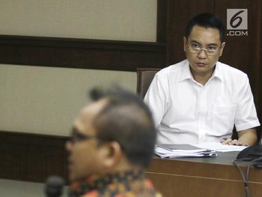 Terdakwa mantan anggota Komisi I DPR, Fayakhun Andriadi (kanan) mendengarkan keterangan saksi Sekretaris DPD Golkar Basri Baco dalam sidang dugaan suap Bakamla di Pengadilan Tipikor, Jakarta, Rabu (12/9). (Liputan6.com/Herman Zakharia)