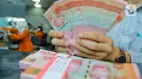 Pegawai menunjukkan mata uang rupiah di salah satu gerai penukaran mata uang di Jakarta, Kamis (5/1/2023). Nilai tukar rupiah ditutup di level Rp15.616 per dolar AS pada Kamis (5/1) sore ini. Mata uang Garuda melemah 34 poin atau minus 0,22 persen dari perdagangan sebelumnya. (Liputan6.com/Angga Yuniar)