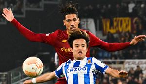 Penyerang Real Sociedad, Takefusa Kubo (Depan) dan bek AS Roma, Chris Smalling mengincar bola pada laga pertama babak 16 besar Liga Europa 2022/2023 di Olimpico, Jumat (10/3/2023) dini hari WIB. Berkat hasil ini, Roma pun berpeluang besar untuk lolos ke babak perempat final. (Photo by Alberto PIZZOLI / AFP)