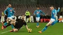 Pemain tengah Napoli Piotr Zielinski menendang bola dan dihadang bek AS Roma menendang bola saat pertandingan Liga Italia Serie A di stadion San Paolo di Naples, Italia (3/3). (AFP Photo/Carlo Hermann)