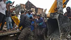 Tim penyelamat membantu korban yang ditarik keluar dari reruntuhan gedung pemerintah yang runtuh saat gempa bumi di Mamuju, Sulawesi Barat, Jumat (15/1/2021). Gempa bermagnitudo 6,2 mengguncang Mamuju, Sulawesi Barat. (AP Photo/Azhari Surahman)