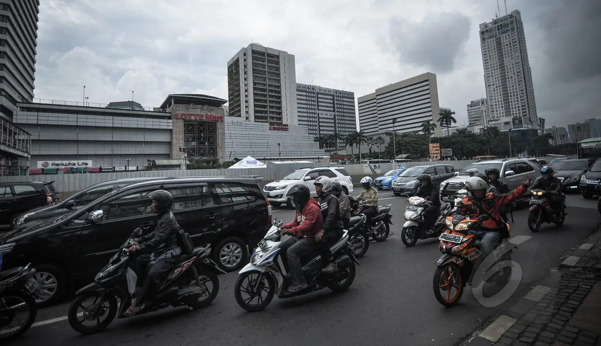 Sejumlah pengendara bermotor roda dua melintas di depan kawasan Ratu Plaza, Jakarta, Selasa (7/4/2015). Pemprov DKI bakal memperluas perlintasan pelarangan sepeda motor hingga Jalan Sudirman (Ratu Plaza) Jakarta Selatan. (Liputan6.com/Faizal Fanani)