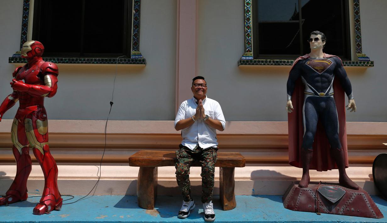 Turis dari Cina foto bersama diantara patung "Iron Man" dan "Superman" di kuil Tamru, Thailand, (3/3). Patung superhero seperti "Hulk", "Superman" dan "Iron Man" dipajang demi menarik pengunjung kuil. (REUTERS/Chaiwat Subprasom)